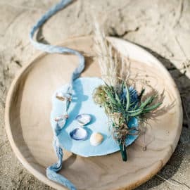 wedding rings in a wooden plate with blue ribbon