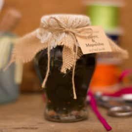 A jar of traditional cypriot sweets by Niki's Traditional Sweets, as a wedding favour gift, decorated with the couple's names and wedding date.