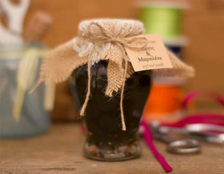A jar of traditional cypriot sweets by Niki's Traditional Sweets, as a wedding favour gift, decorated with the couple's names and wedding date.