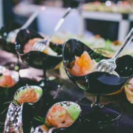 Appetisers with caviar in stylish black bowls at a wedding dinner, produced by Sans Frontieres Catering.