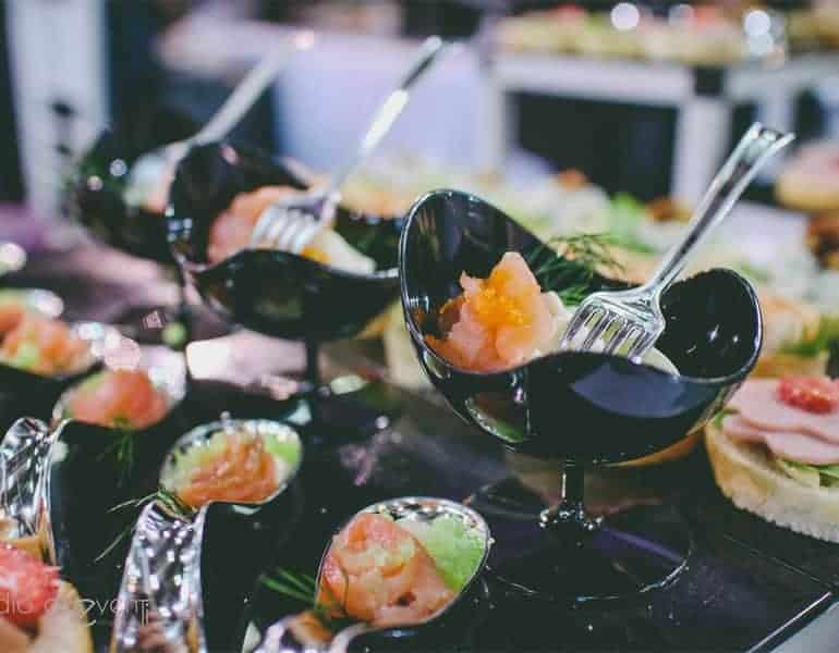 Appetisers with caviar in stylish black bowls at a wedding dinner, produced by Sans Frontieres Catering.